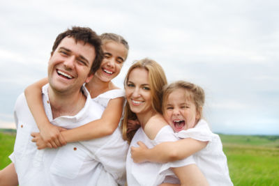 Life insurance featured image - Happy young family with two children outdoors